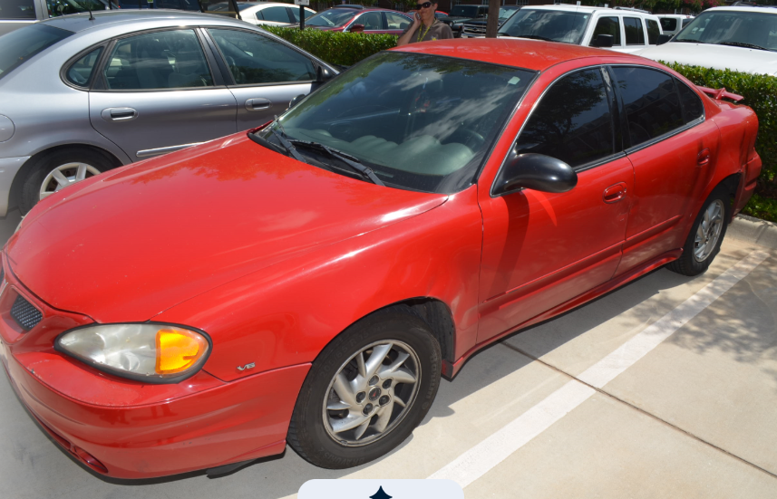 Photograph of Jannie Ligons's red Pontiac Grand Am with darkly tinted windows.
